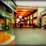 Explore the lively atmosphere of a modern shopping mall in Hoofddorp, Netherlands, captured with vibrant colors and motion blur.